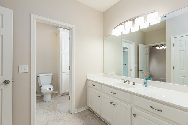 bathroom with vanity, ceiling fan, and toilet