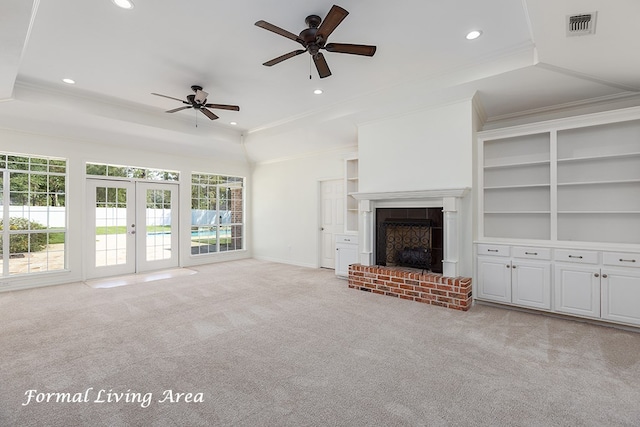 unfurnished living room featuring a fireplace, light colored carpet, a healthy amount of sunlight, and ornamental molding