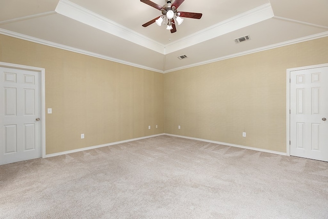 carpeted empty room featuring ceiling fan, ornamental molding, and a tray ceiling