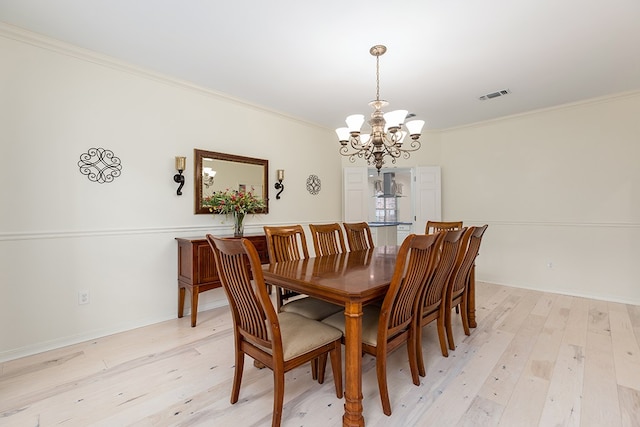 dining space featuring a chandelier, light hardwood / wood-style flooring, and ornamental molding