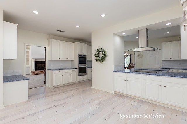 kitchen featuring black electric stovetop, double oven, exhaust hood, white cabinets, and light hardwood / wood-style floors