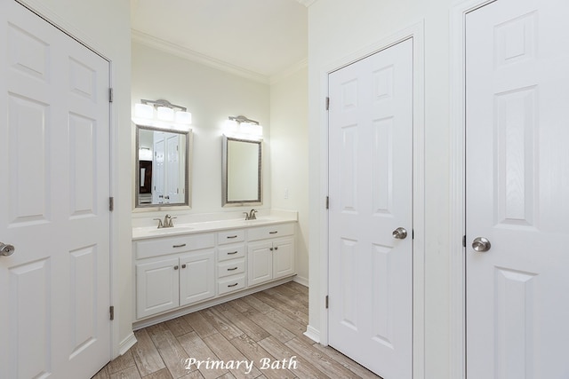 bathroom with crown molding, vanity, and hardwood / wood-style flooring