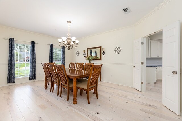 dining room with a notable chandelier, crown molding, and light hardwood / wood-style flooring