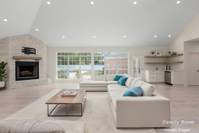 living room featuring a fireplace, light hardwood / wood-style floors, and vaulted ceiling