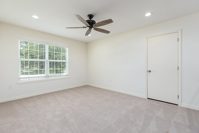 spare room featuring ceiling fan and light colored carpet