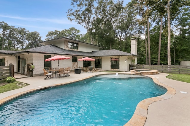view of swimming pool featuring an in ground hot tub and a patio