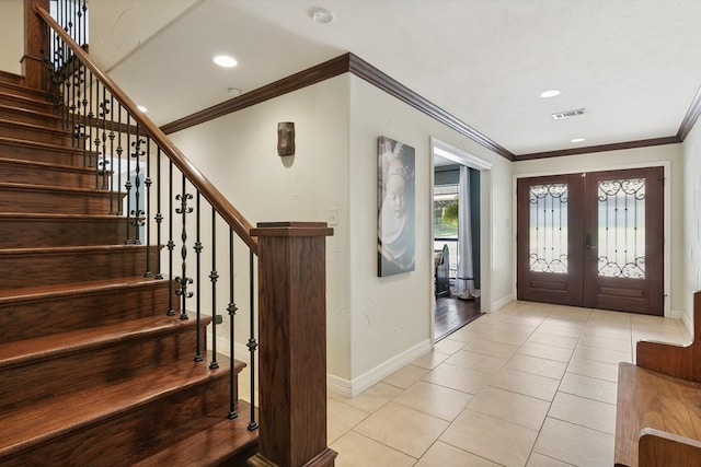 tiled entryway featuring crown molding and french doors