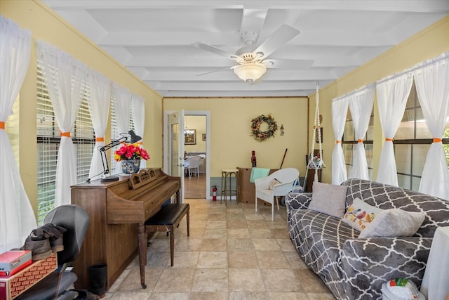 sitting room with ceiling fan and beamed ceiling