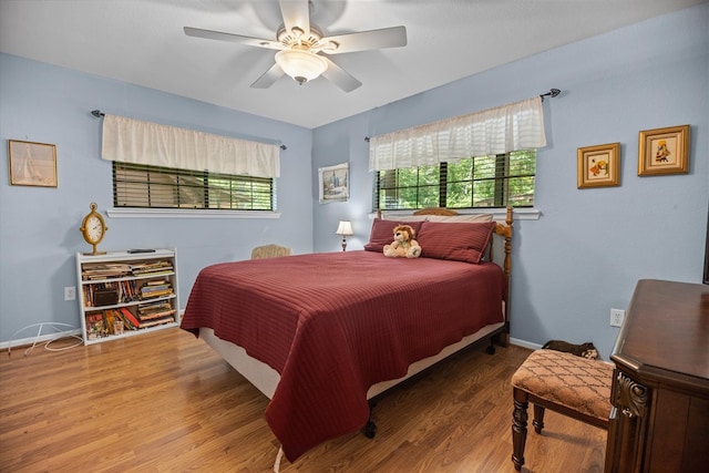 bedroom with hardwood / wood-style flooring, multiple windows, and ceiling fan