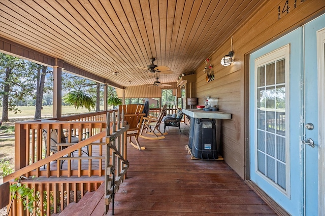 wooden terrace featuring ceiling fan and covered porch