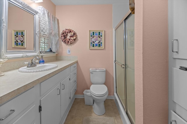 bathroom featuring vanity, toilet, and an enclosed shower