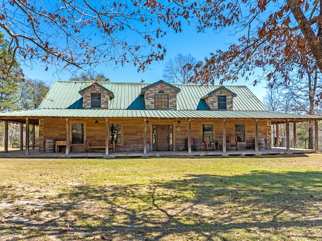 view of front facade featuring covered porch, metal roof, and a front yard