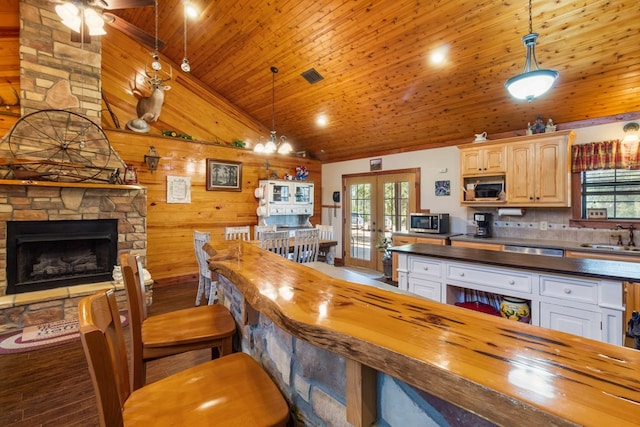 kitchen featuring stainless steel microwave, french doors, wood counters, and a sink