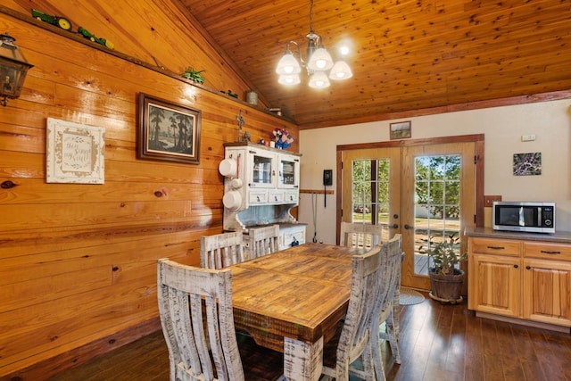 dining space featuring dark wood finished floors, french doors, an inviting chandelier, wood ceiling, and vaulted ceiling