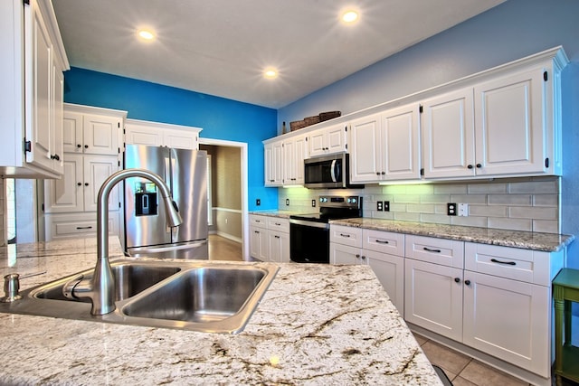 160 Somerset, Milam, TX 75959 - kitchen featuring white cabinetry, sink, light stone countertops, stainless steel appliances, and backsplash