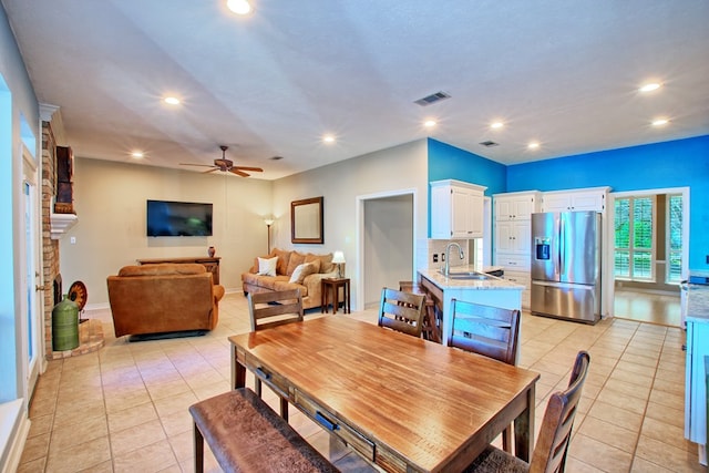 160 Somerset, Milam, TX 75959 - dining space featuring a fireplace, light tile patterned floors, ceiling fan, and sink