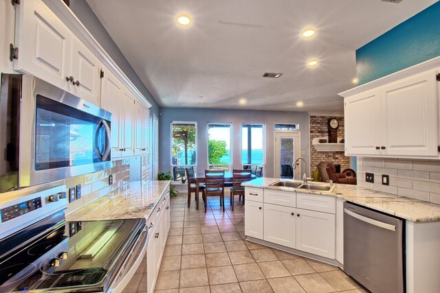 160 Somerset, Milam, TX 75959 - kitchen featuring a fireplace, stainless steel appliances, white cabinetry, and sink