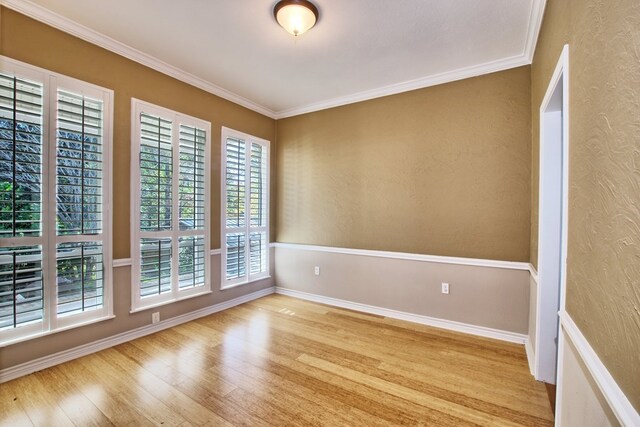 160 Somerset, Milam, TX 75959 - unfurnished room featuring crown molding, plenty of natural light, and light wood-type flooring