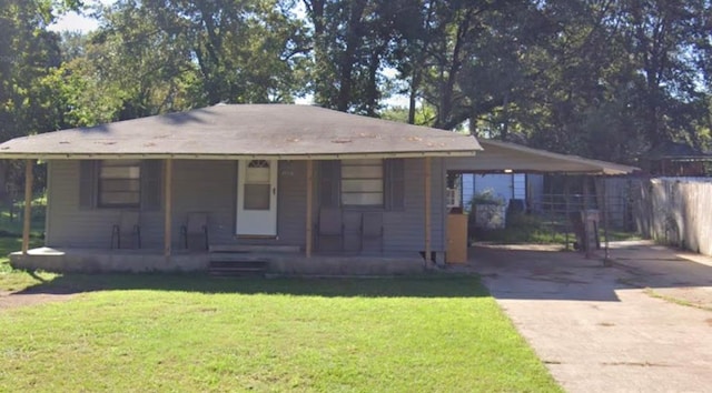 single story home featuring a porch, fence, a front lawn, driveway, and an attached carport