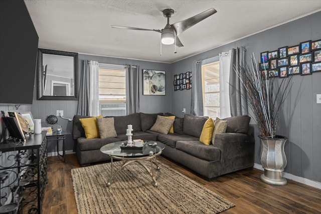 living room featuring wood finished floors, ceiling fan, baseboards, and a wealth of natural light