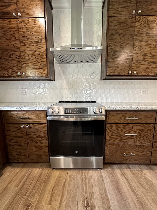 130CR740 County Road 740, Buna, TX 77612 - kitchen with stainless steel electric stove, wall chimney exhaust hood, light wood-style floors, and tasteful backsplash