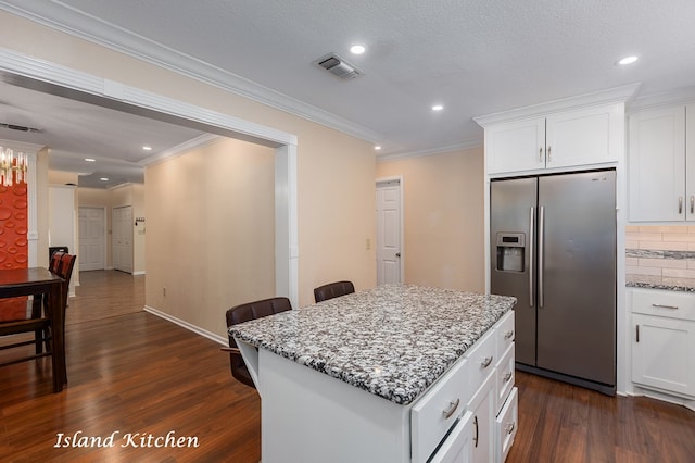 309 Hunters Creek Dr, Lufkin, TX 75901 - kitchen featuring stainless steel refrigerator with ice dispenser, dark wood-style flooring, crown molding, light stone counters, and backsplash