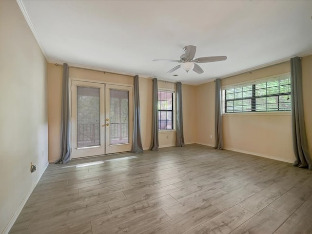 empty room featuring ceiling fan, light wood-type flooring, ornamental molding, and french doors