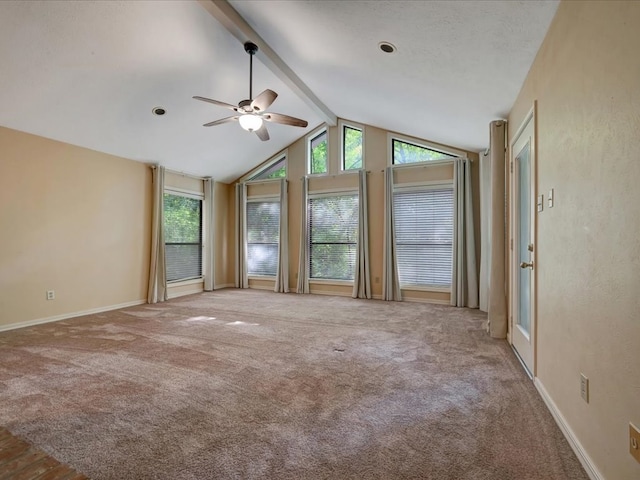 carpeted spare room featuring vaulted ceiling with beams, ceiling fan, and plenty of natural light