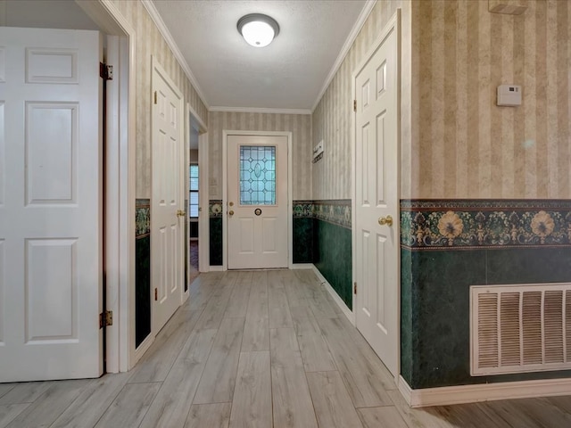 entryway with light hardwood / wood-style flooring and ornamental molding