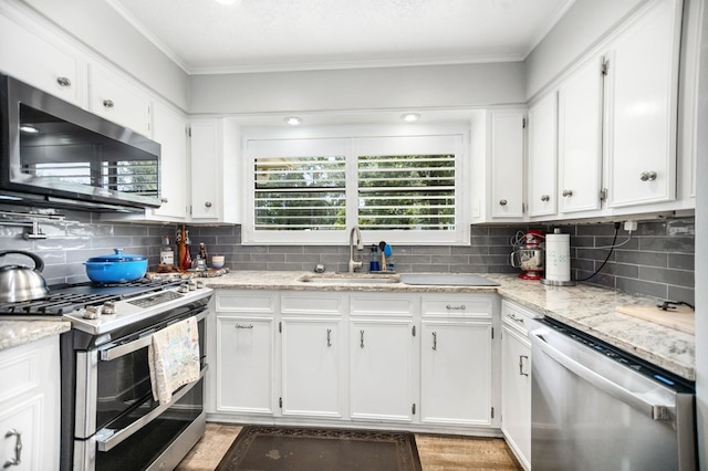 1405 Oak Hill Pl, Lufkin, TX 75904 - kitchen featuring stainless steel appliances, ornamental molding, white cabinets, decorative backsplash, and light stone countertops