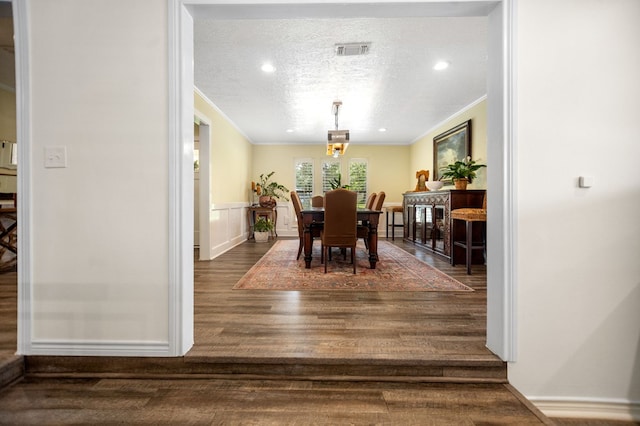 1405 Oak Hill Pl, Lufkin, TX 75904 - dining room featuring ornamental molding, wood finished floors, a textured ceiling, and wainscoting