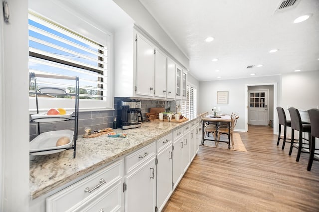 1405 Oak Hill Pl, Lufkin, TX 75904 - kitchen featuring tasteful backsplash, white cabinetry, recessed lighting, light wood finished floors, and light stone countertops