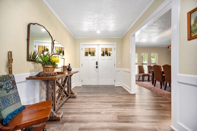 1405 Oak Hill Pl, Lufkin, TX 75904 - foyer featuring ornamental molding, wood finished floors, a textured ceiling, and wainscoting