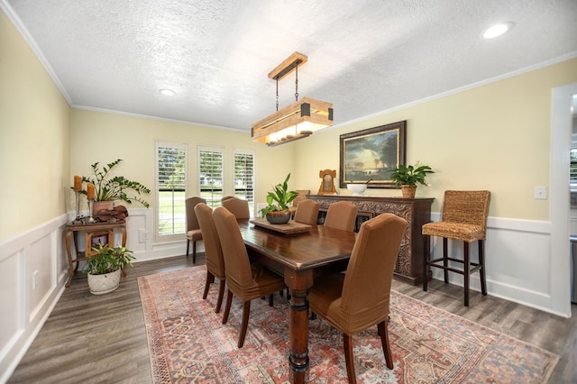 1405 Oak Hill Pl, Lufkin, TX 75904 - dining area featuring a textured ceiling, wood finished floors, ornamental molding, a wainscoted wall, and recessed lighting