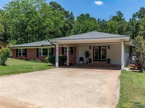 ranch-style house with brick siding, concrete driveway, and a front yard