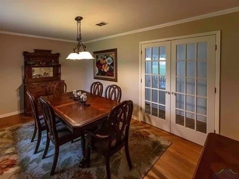 dining room featuring baseboards, ornamental molding, wood finished floors, and french doors