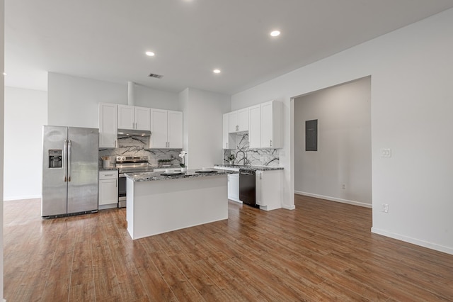 20 Coolcrest Dr, Point Blank, TX 77364 - kitchen with appliances with stainless steel finishes, under cabinet range hood, backsplash, white cabinetry, and recessed lighting