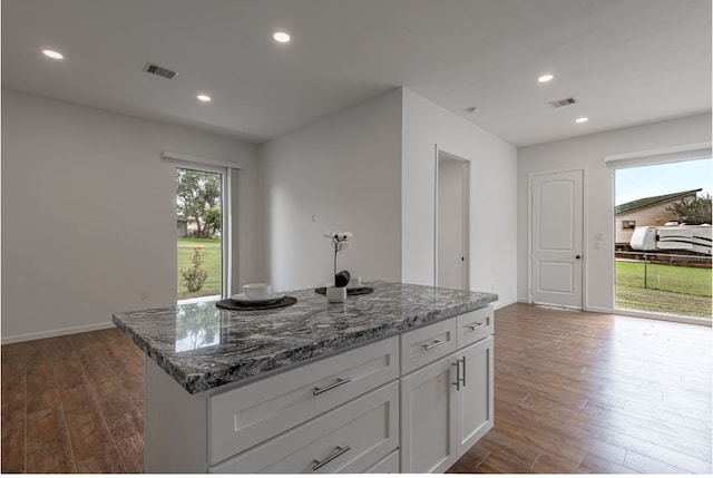 20 Coolcrest Dr, Point Blank, TX 77364 - kitchen featuring dark wood finished floors, white cabinetry, recessed lighting, stone countertops, and a center island