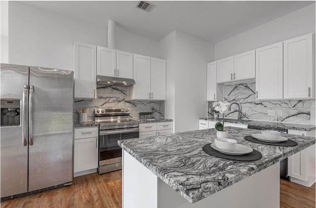 20 Coolcrest Dr, Point Blank, TX 77364 - kitchen with stainless steel appliances, under cabinet range hood, white cabinets, and dark stone counters
