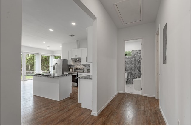 20 Coolcrest Dr, Point Blank, TX 77364 - kitchen featuring appliances with stainless steel finishes, dark wood-type flooring, white cabinets, a kitchen island with sink, and under cabinet range hood