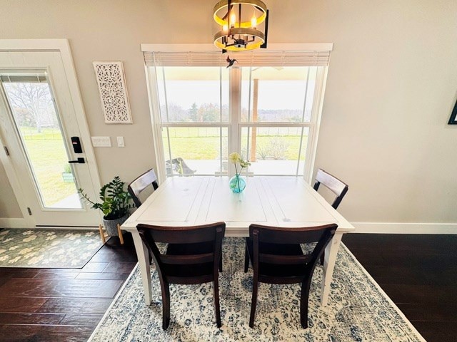 304 Lcr 485, Mexia, TX 76667 - dining area with dark wood-type flooring, a chandelier, baseboards, and plenty of natural light