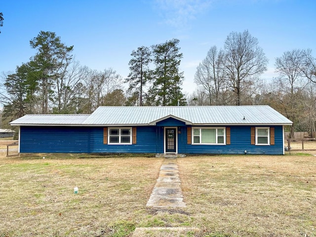 view of front of property featuring metal roof and a front yard