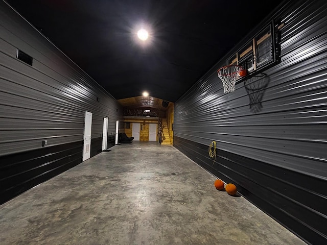 hall with concrete flooring and wooden walls