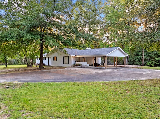 ranch-style house featuring covered porch and a front lawn