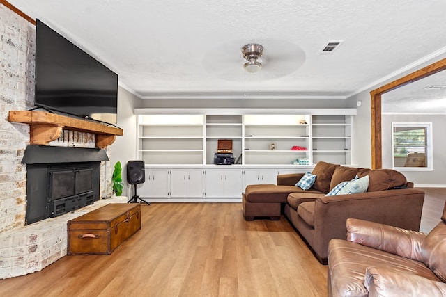 living room featuring a textured ceiling, ceiling fan, light hardwood / wood-style floors, and crown molding