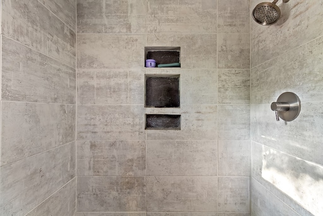 interior details with a tile shower