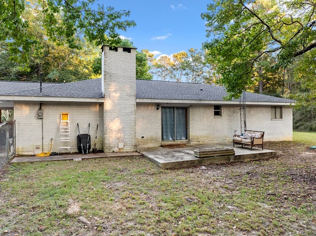 rear view of property with a lawn and a patio area