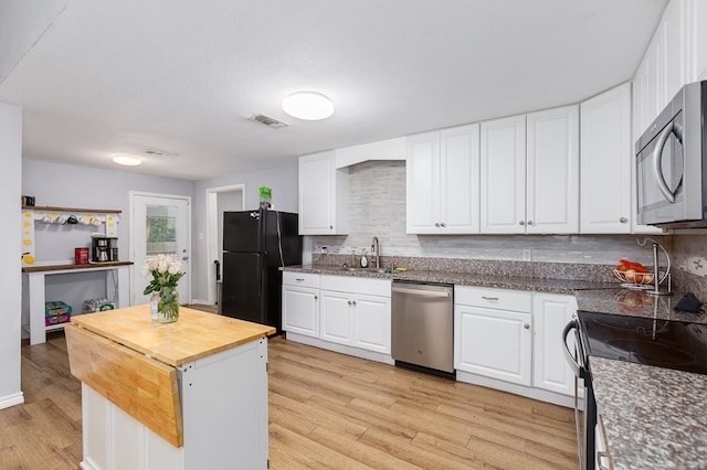 240 W 7th St, Trinity, TX 75862 - kitchen featuring stainless steel appliances, wood counters, light wood-style flooring, and white cabinets