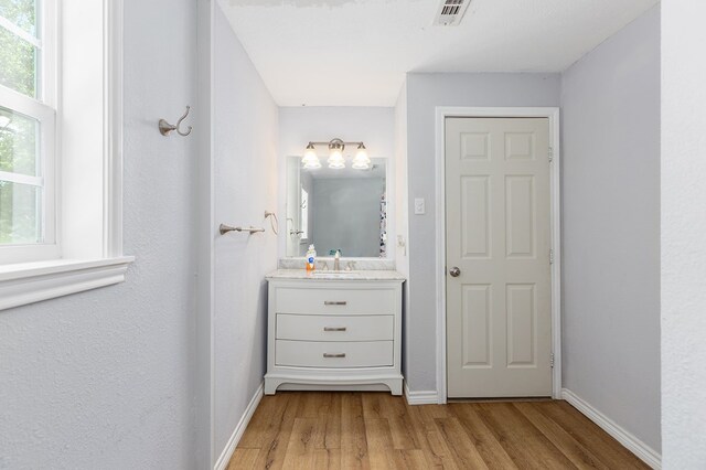 240 W 7th St, Trinity, TX 75862 - bathroom featuring wood finished floors, baseboards, and vanity