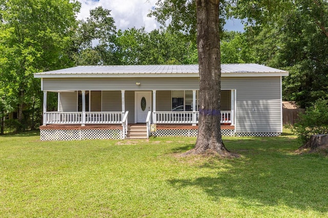 240 W 7th St, Trinity, TX 75862 - view of front of home featuring covered porch, a front yard, and metal roof